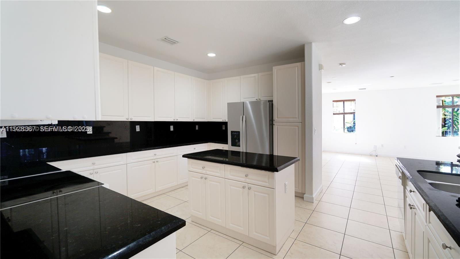 7507 Southwest 189th Street, Unit 7507 Cutler Bay, FL 33157 - Photo 12 of 28 a kitchen with stainless steel appliances a refrigerator a stove a sink and white cabinets