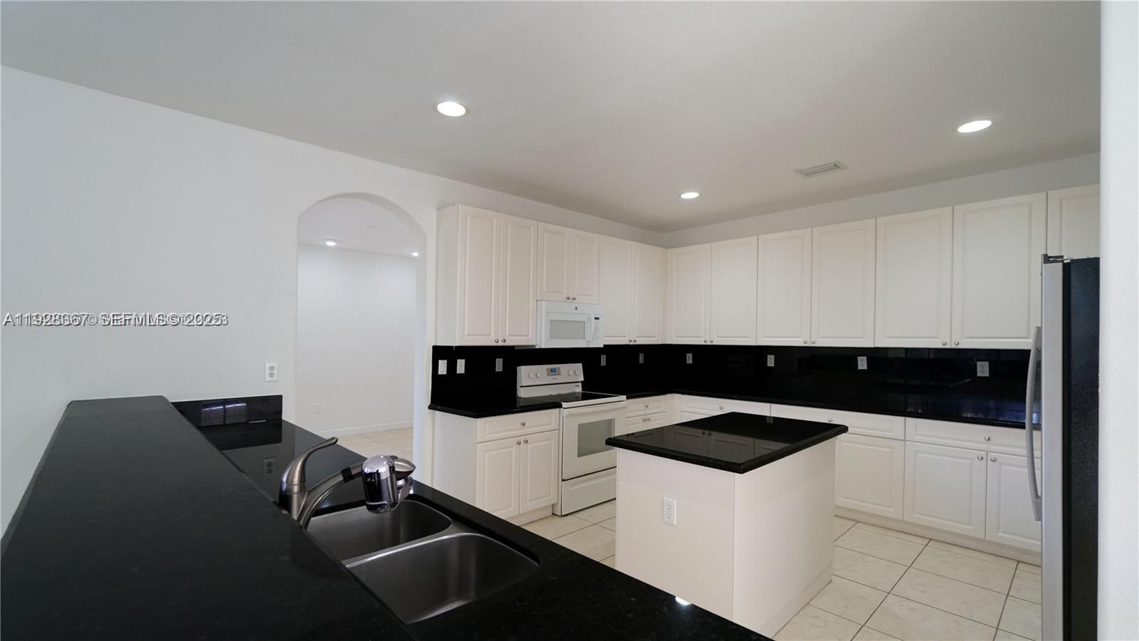 7507 Southwest 189th Street, Unit 7507 Cutler Bay, FL 33157 - Photo 13 of 28 a kitchen with a sink and white cabinets