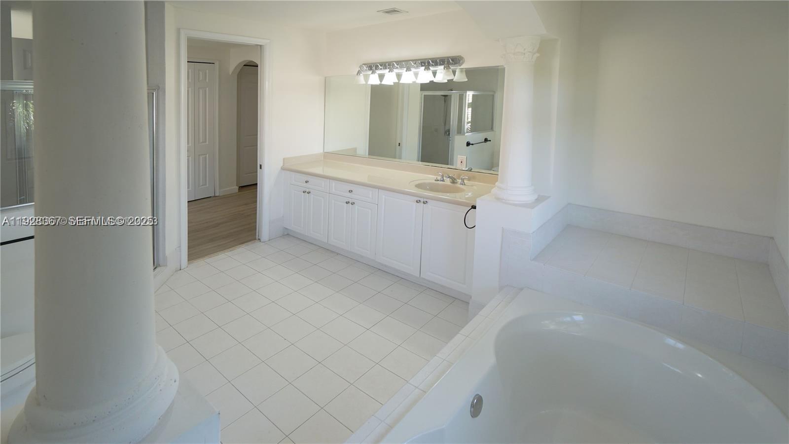 7507 Southwest 189th Street, Unit 7507 Cutler Bay, FL 33157 - Photo 18 of 28 a bathroom with a double vanity sink and mirror