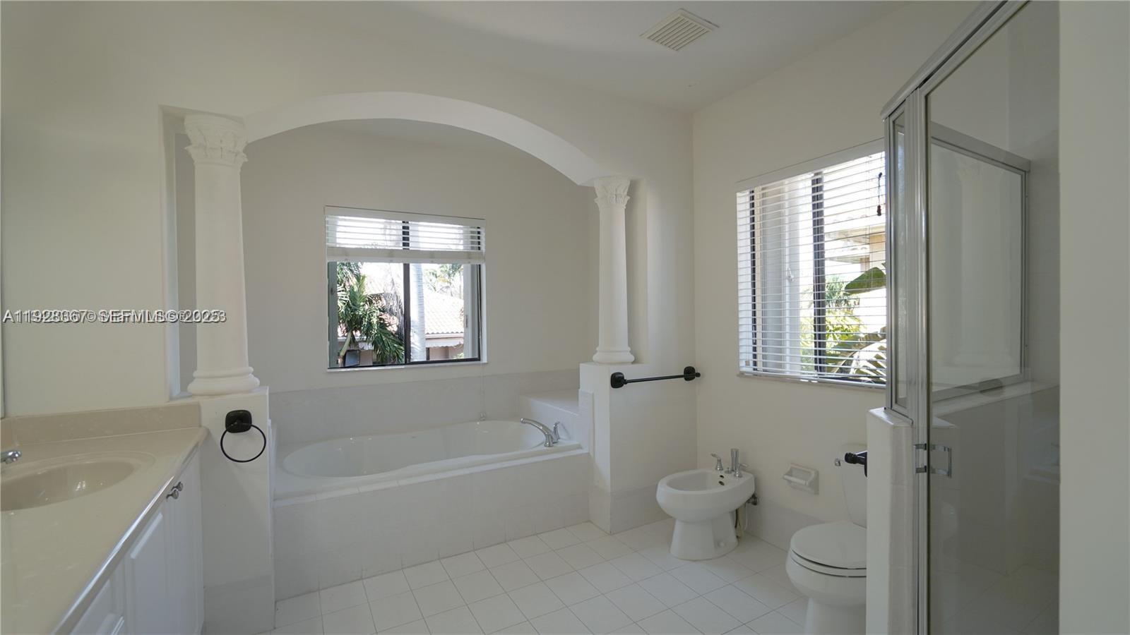 7507 Southwest 189th Street, Unit 7507 Cutler Bay, FL 33157 - Photo 19 of 28 a bath room with a toilet a bath tub and a window