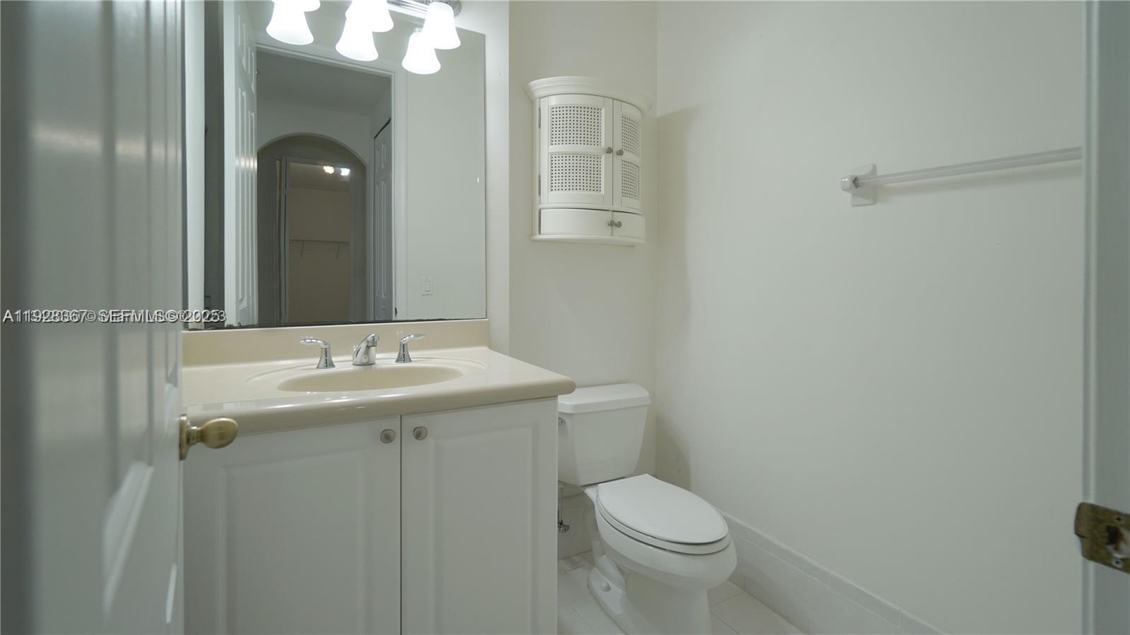 7507 Southwest 189th Street, Unit 7507 Cutler Bay, FL 33157 - Photo 20 of 28 a bathroom with a toilet a sink and mirror