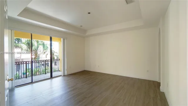 an empty room with wooden floor & closet area