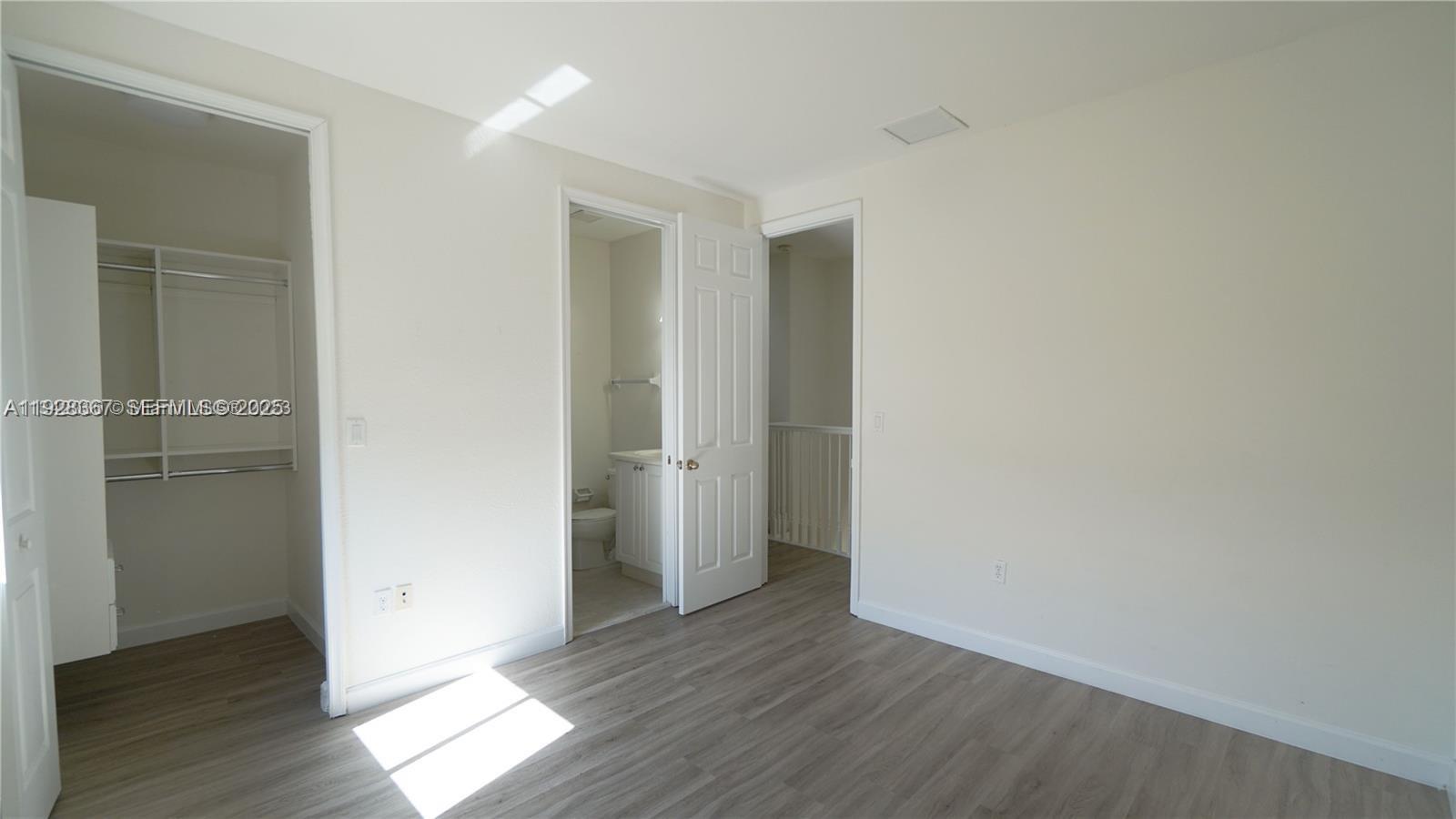 7507 Southwest 189th Street, Unit 7507 Cutler Bay, FL 33157 - Photo 24 of 28 an empty room with wooden floor & closet area