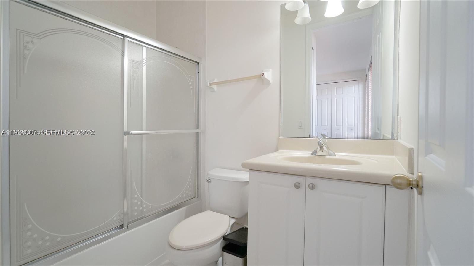 7507 Southwest 189th Street, Unit 7507 Cutler Bay, FL 33157 - Photo 26 of 28 a bathroom with a granite countertop sink toilet and shower