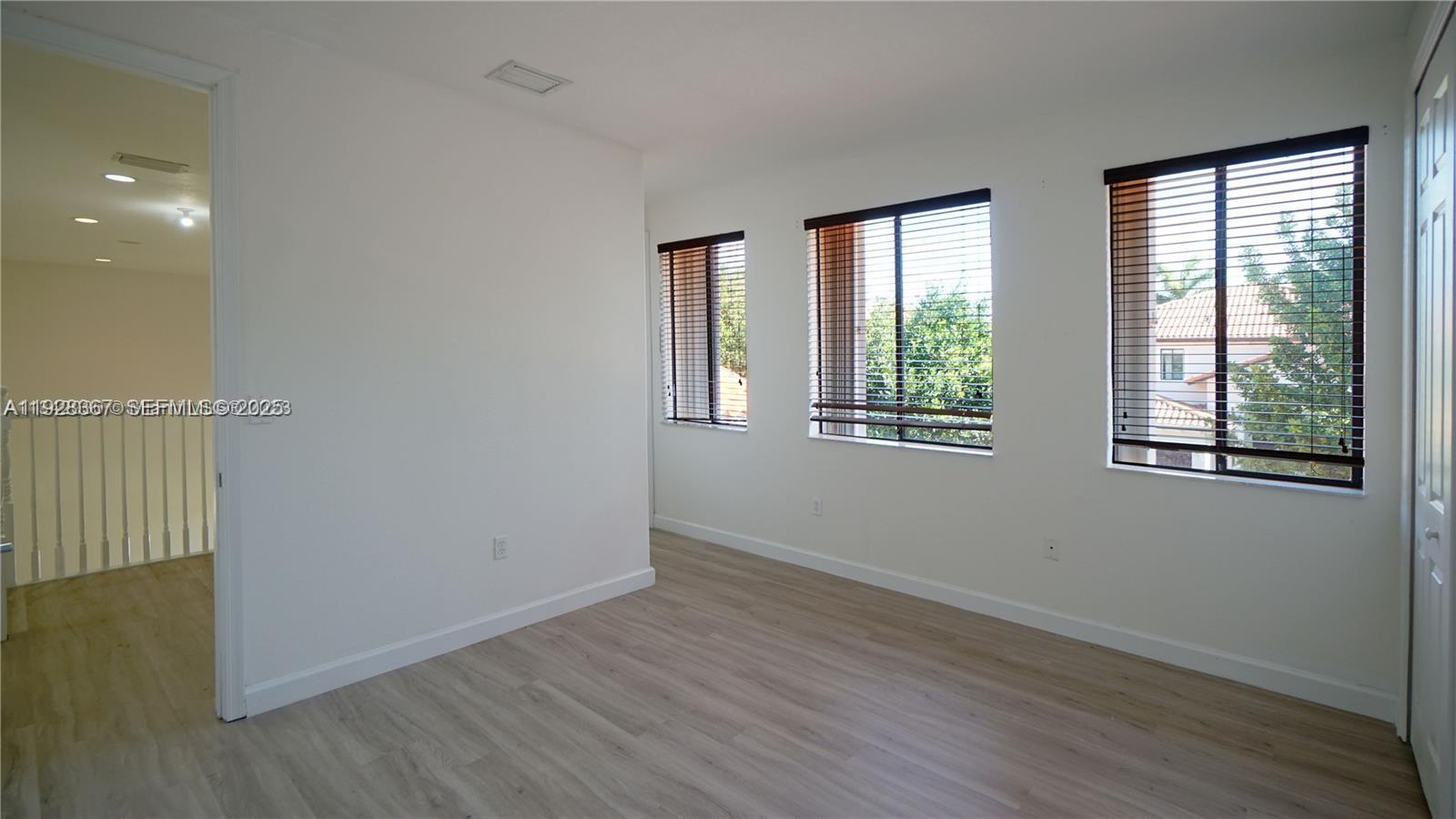 7507 Southwest 189th Street, Unit 7507 Cutler Bay, FL 33157 - Photo 28 of 28 a view of an empty room with wooden floor and a window