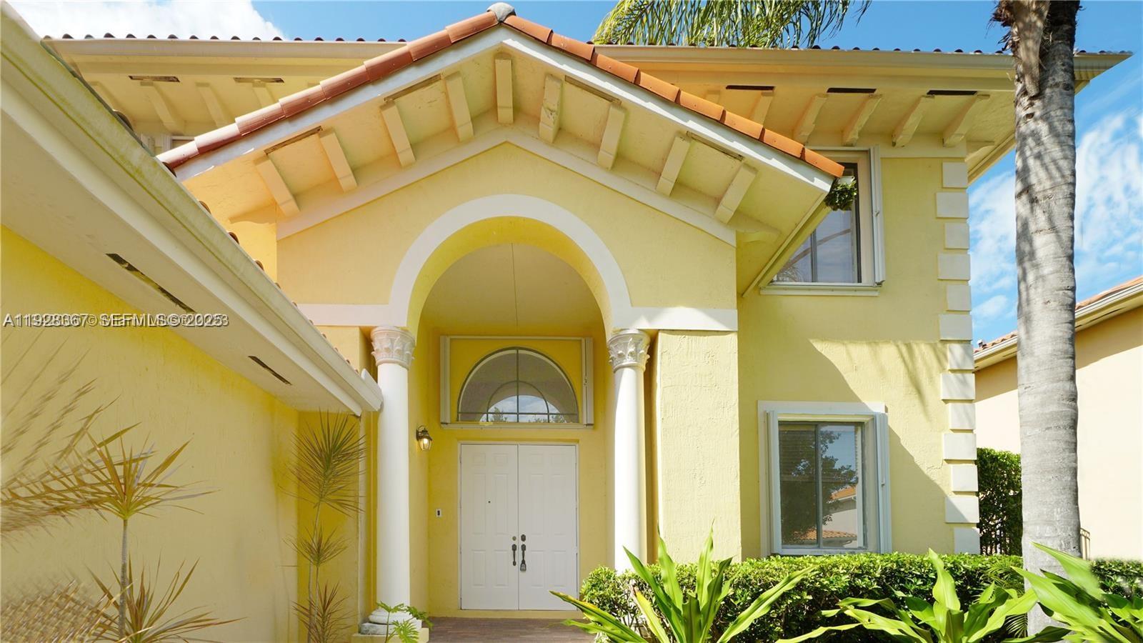 7507 Southwest 189th Street, Unit 7507 Cutler Bay, FL 33157 - Photo 3 of 28 a blue yellow and white house with a clock on the wall