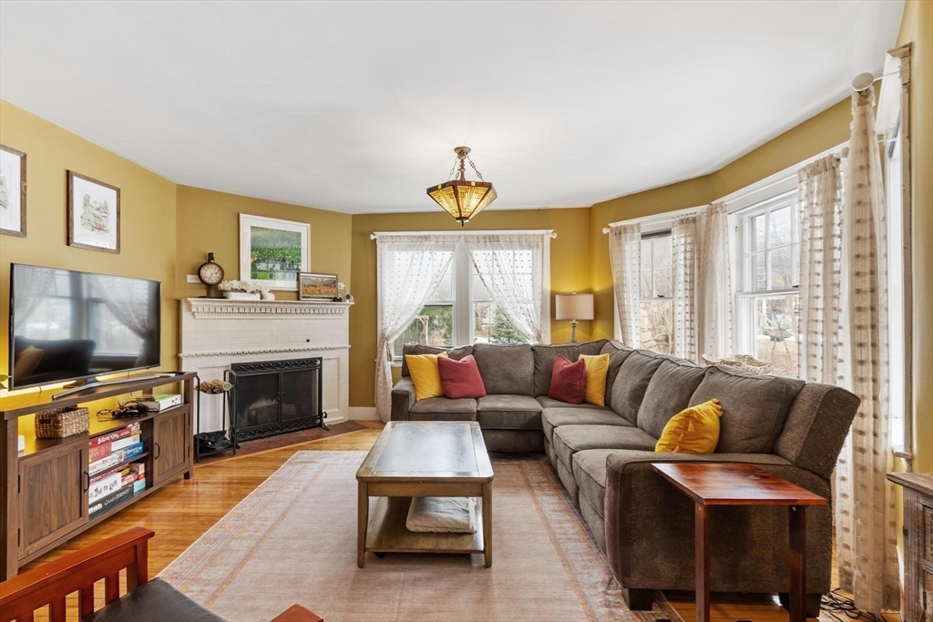 20 Shattuck Street Littleton, MA 01460 - Photo 12 of 41 a living room with furniture a flat screen tv and a fireplace