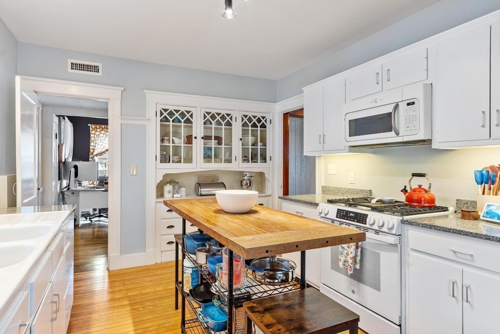 20 Shattuck Street Littleton, MA 01460 - Photo 19 of 41 a kitchen with stainless steel appliances granite countertop a stove a sink dishwasher and cabinets with wooden floor