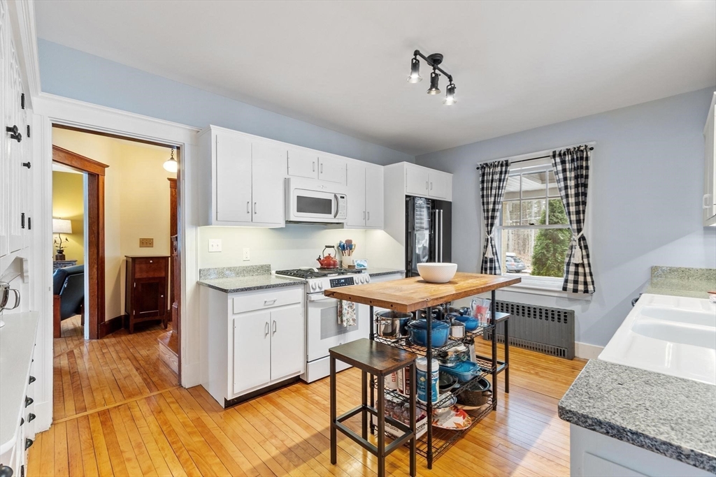 20 Shattuck Street Littleton, MA 01460 - Photo 21 of 41 a kitchen with stainless steel appliances granite countertop a stove top oven a sink dishwasher and a dining table with granite countertops