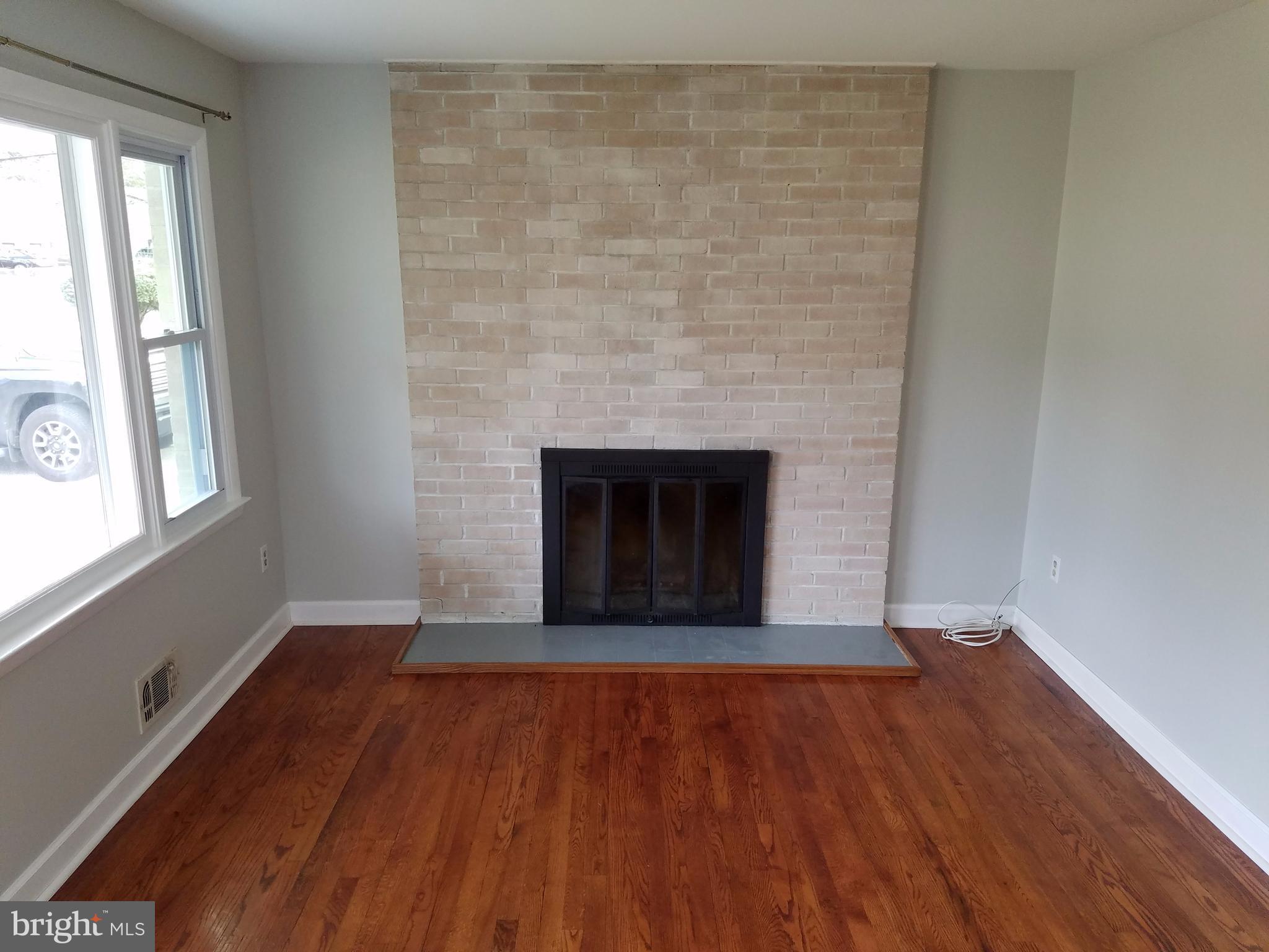 1335 Ava Road Severn, MD 21144 - Photo 2 of 13 wooden floor fireplace and windows in an empty room