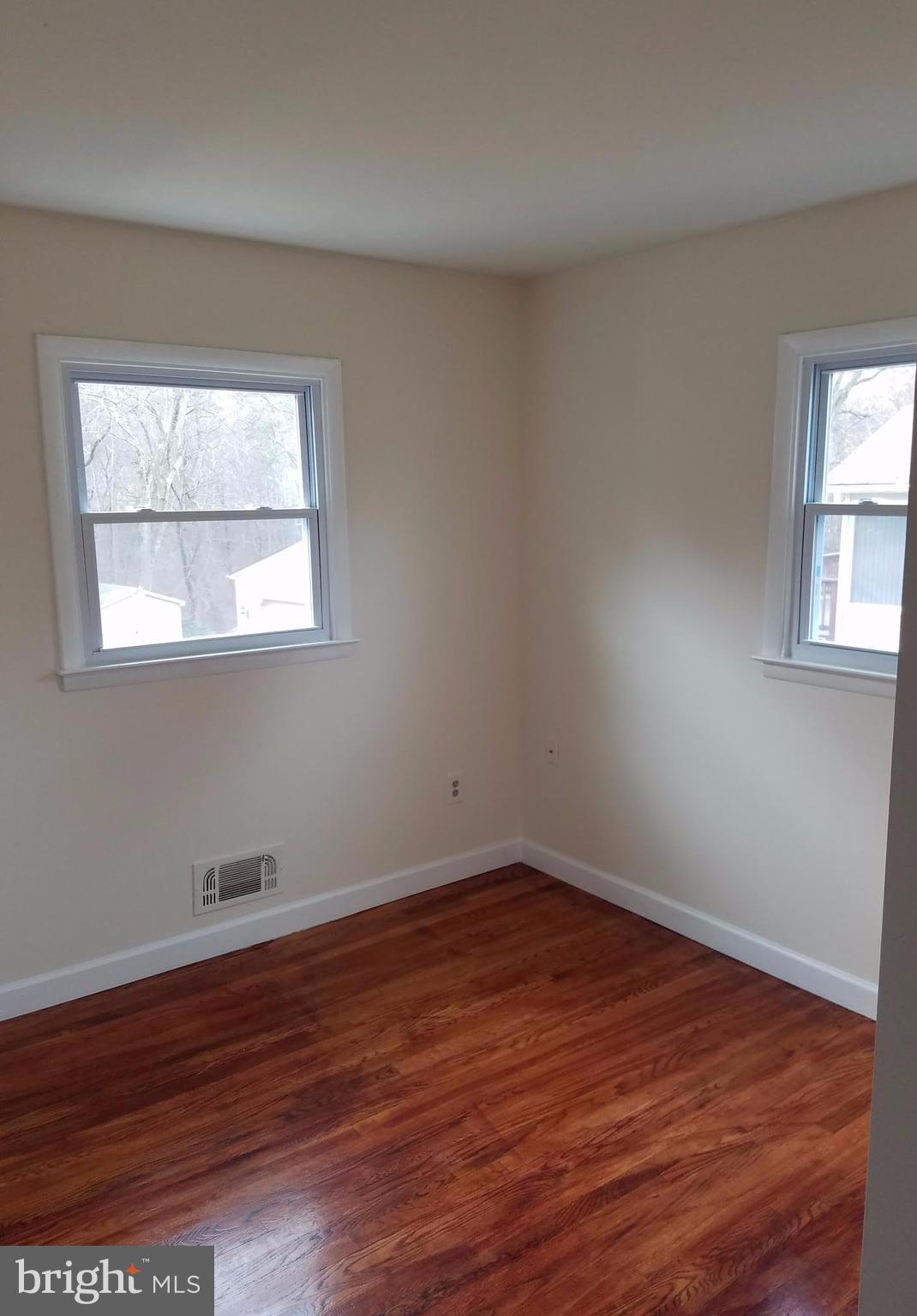 1335 Ava Road Severn, MD 21144 - Photo 7 of 13 an empty room with wooden floor and windows