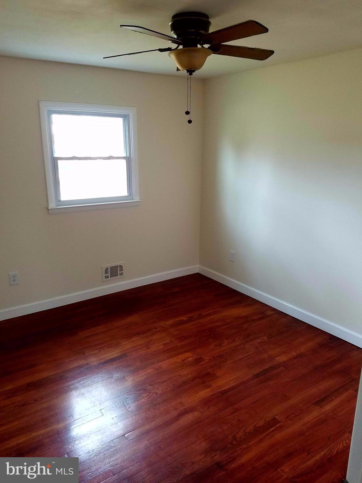 1335 Ava Road Severn, MD 21144 - Photo 9 of 13 an empty room with wooden floor fan and windows