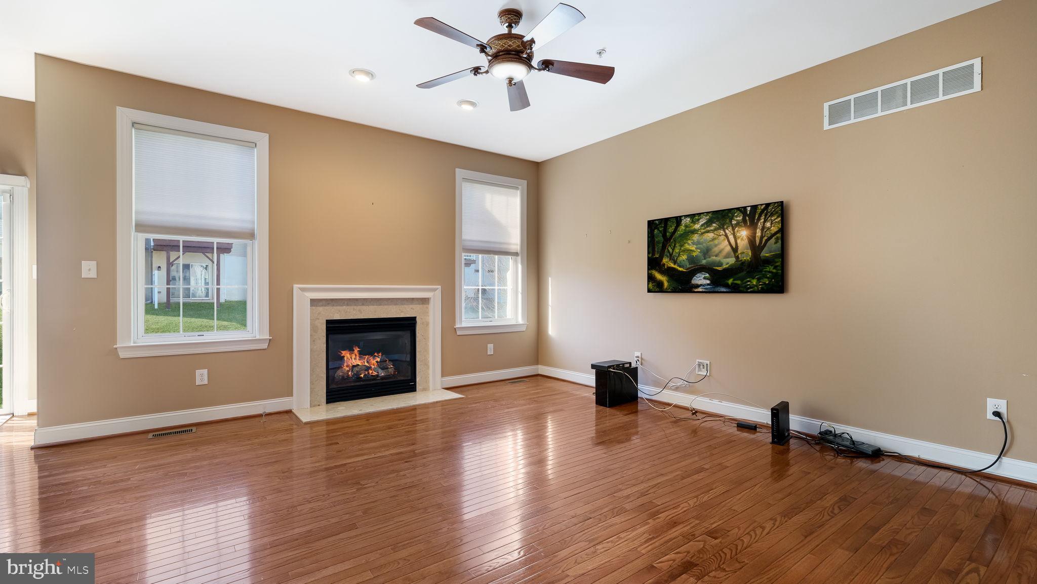 2372 Dorchester Street West, Unit W Furlong, PA 18925 - Photo 13 of 41 a view of a livingroom with a fireplace a ceiling fan and windows
