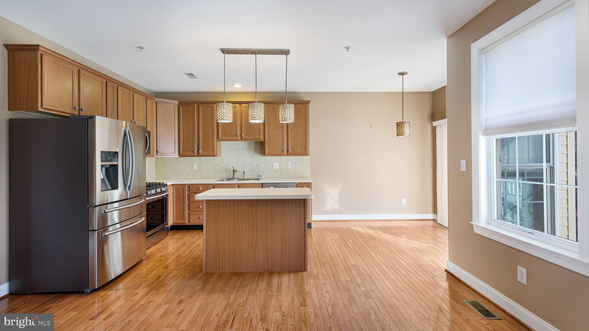 2372 Dorchester Street West, Unit W Furlong, PA 18925 - Photo 15 of 41 a kitchen with stainless steel appliances granite countertop a refrigerator a sink dishwasher a stove and white countertops with wooden floor