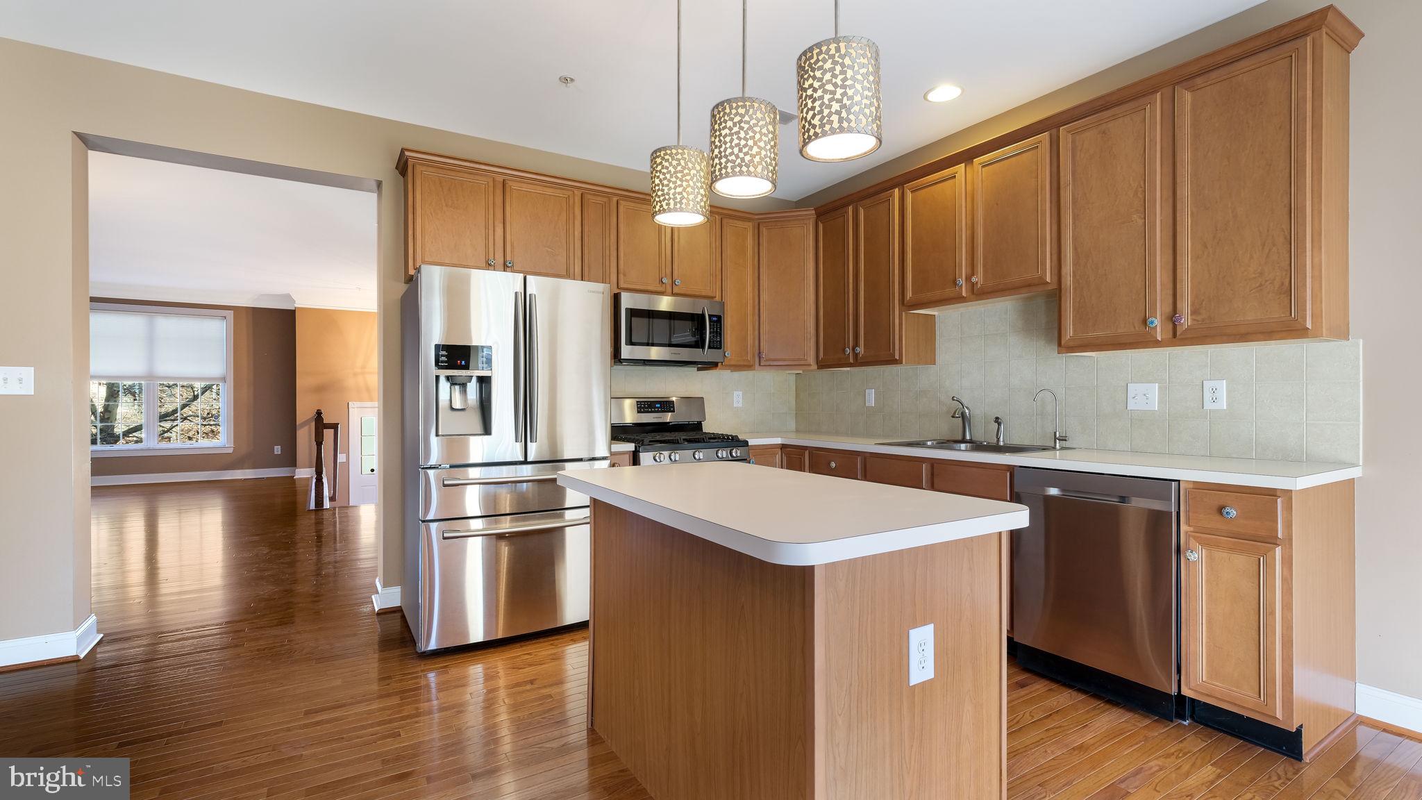 2372 Dorchester Street West, Unit W Furlong, PA 18925 - Photo 17 of 41 a kitchen with stainless steel appliances granite countertop a refrigerator a sink dishwasher a stove and a microwave oven with wooden floor