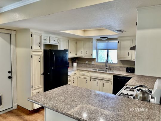 401 South Lincoln Street Ridgecrest, CA 93555 - Photo 7 of 27 a kitchen with granite countertop a refrigerator stove and sink