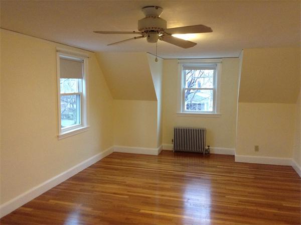 55 High Street Needham, MA 02494 - Photo 8 of 15 a view of an empty room with a window and wooden floor