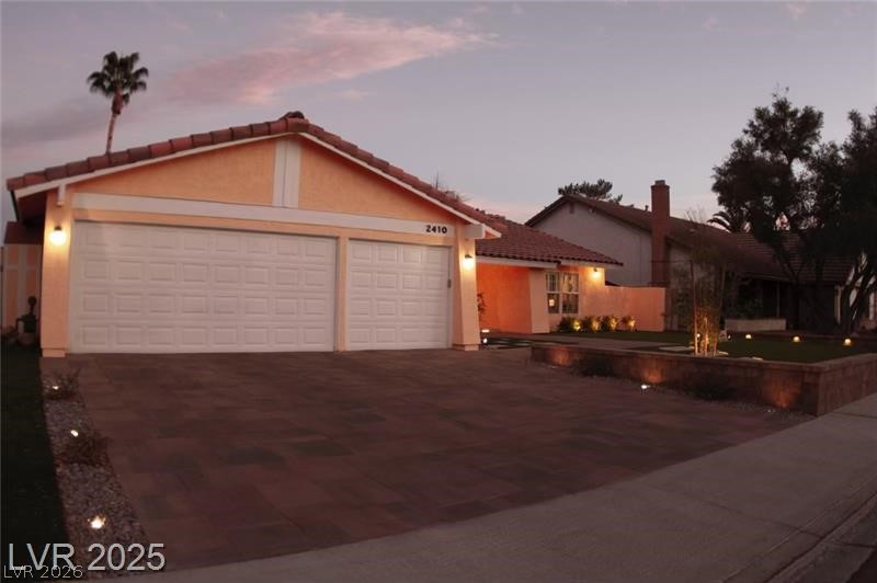 2410 Doherty Way Henderson, NV 89014 - Photo 61 of 63 View of front of property featuring stucco siding, a tiled roof, asphalt driveway, and a garage