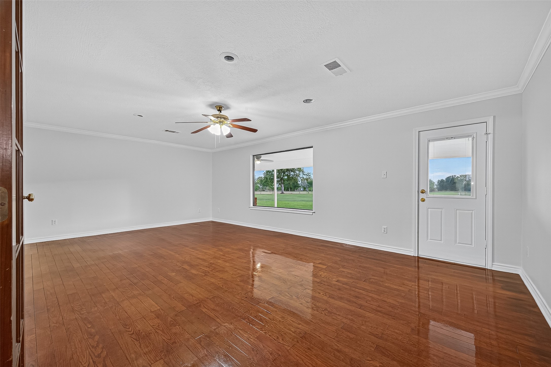 3122 Kueck Road Rosenberg, TX 77471 - Photo 8 of 25 a view of an empty room with wooden floor and a window