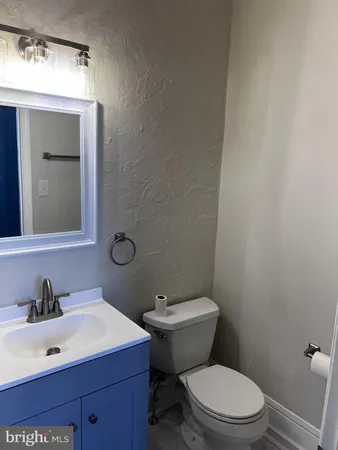 a bathroom with a sink mirror vanity and toilet