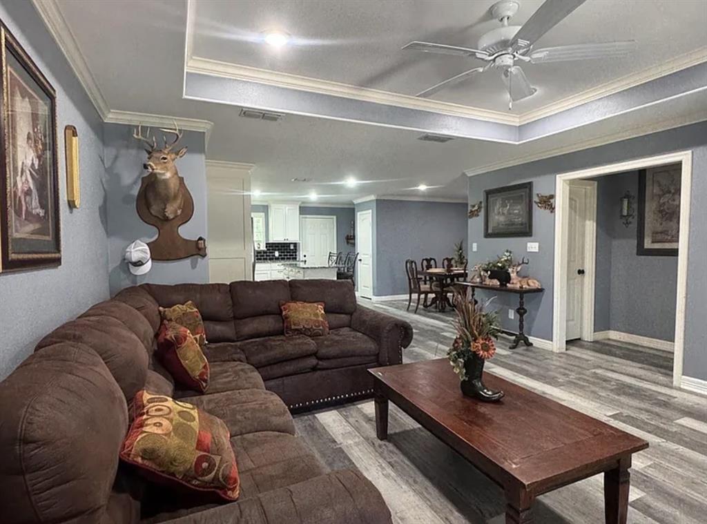 8261 County Road 381 Tyler, TX 75708 - Photo 28 of 40 a living room with furniture a clock and a chandelier