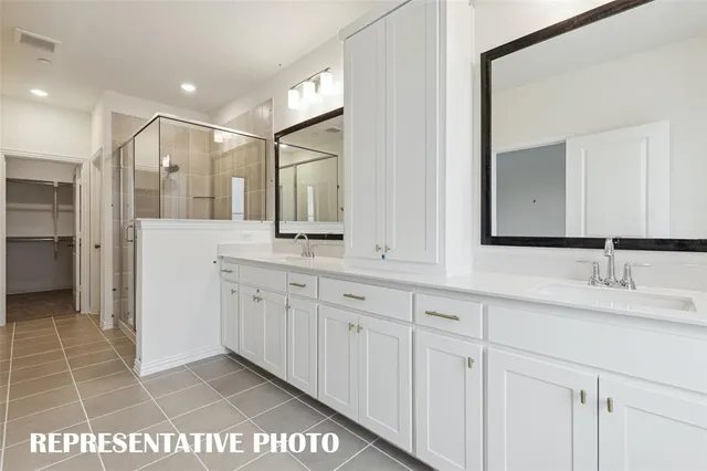 a bathroom with white cabinets and sink