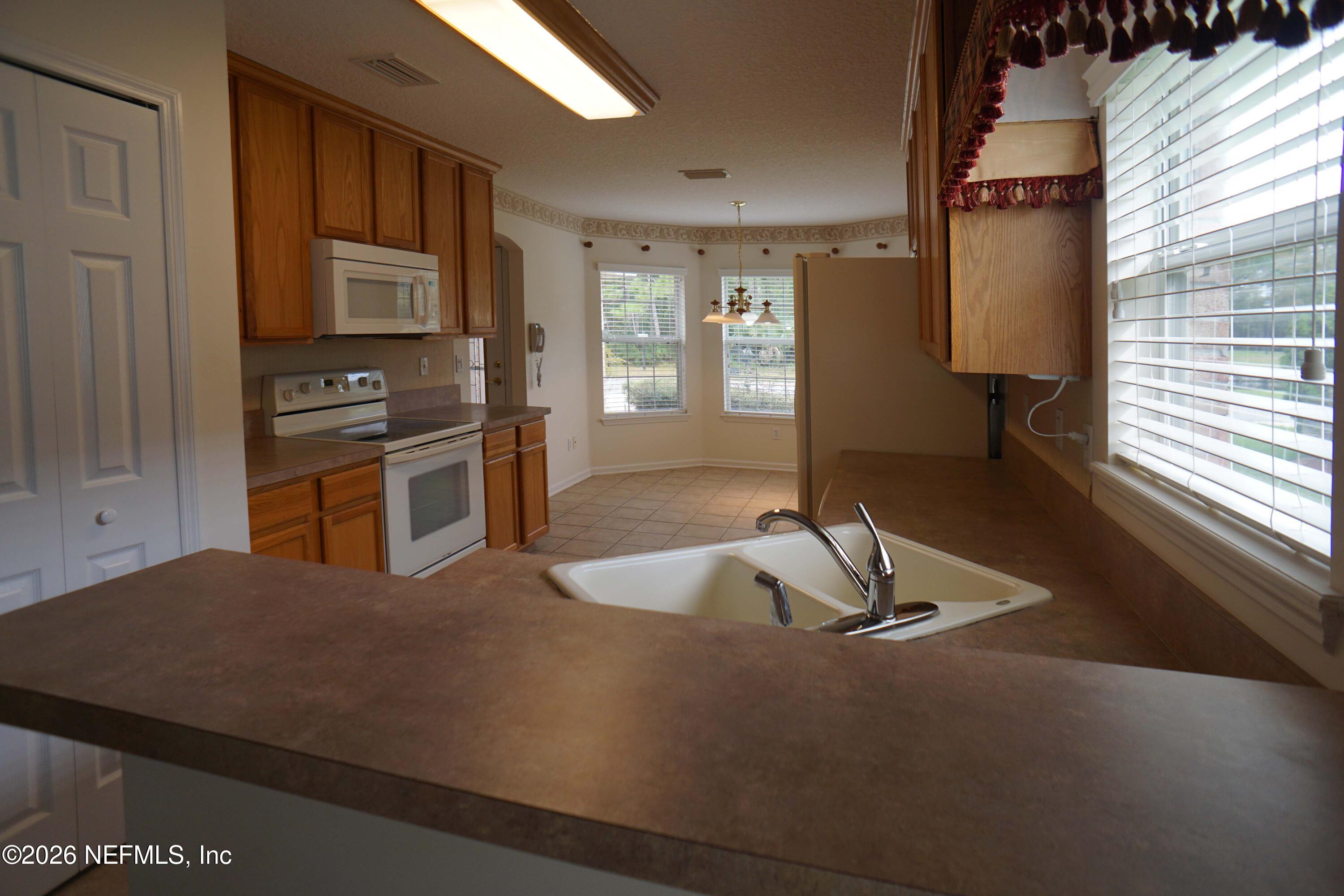 1721 Keswick Road St. Augustine, FL 32084 - Photo 3 of 17 a kitchen with sink refrigerator and window