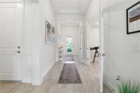 a view of a hallway with wooden floor and a living room