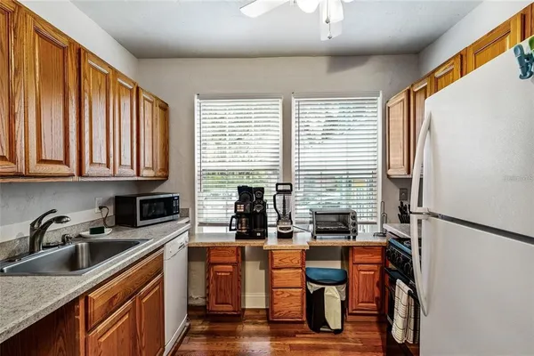 a kitchen with stainless steel appliances granite countertop sink refrigerator and window