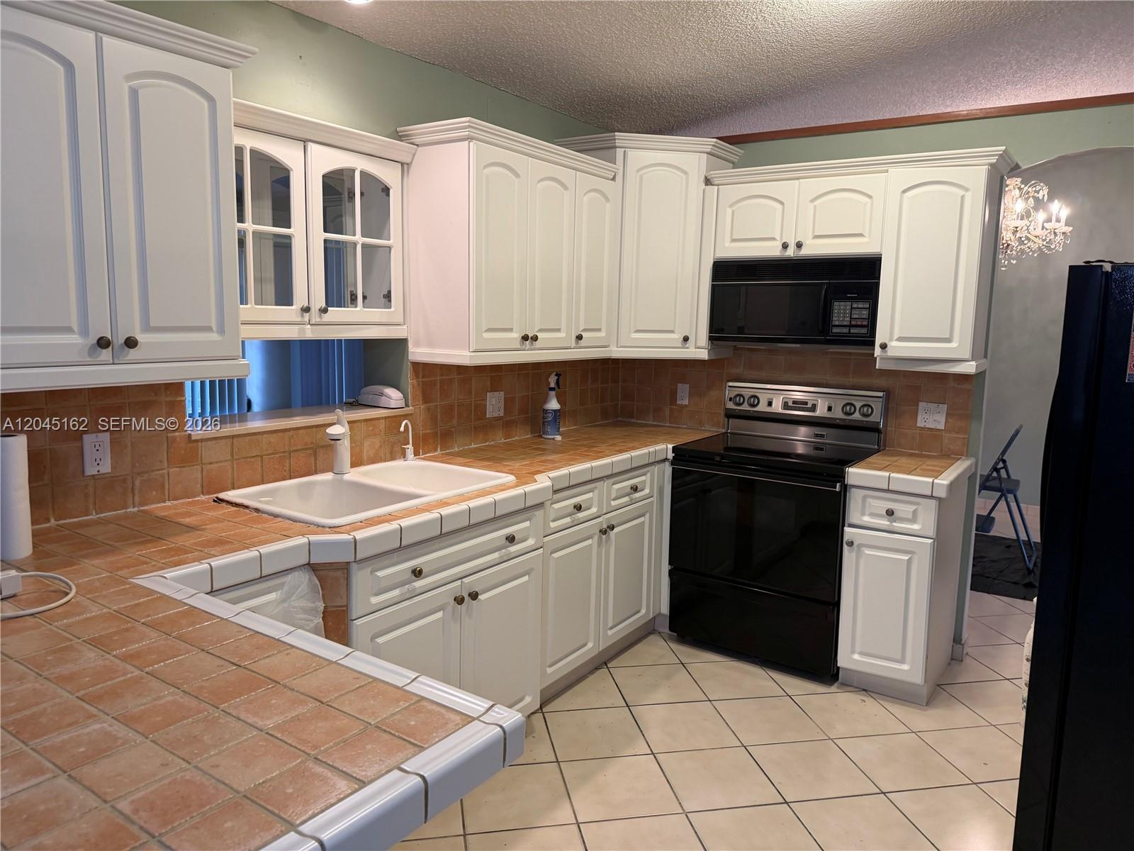 3262 Southwest 139th Place Miami, FL 33175 - Photo 7 of 36 a kitchen with stainless steel appliances granite countertop a stove a sink and a microwave