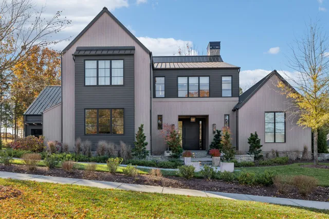 a front view of a house with a yard outdoor seating and garage