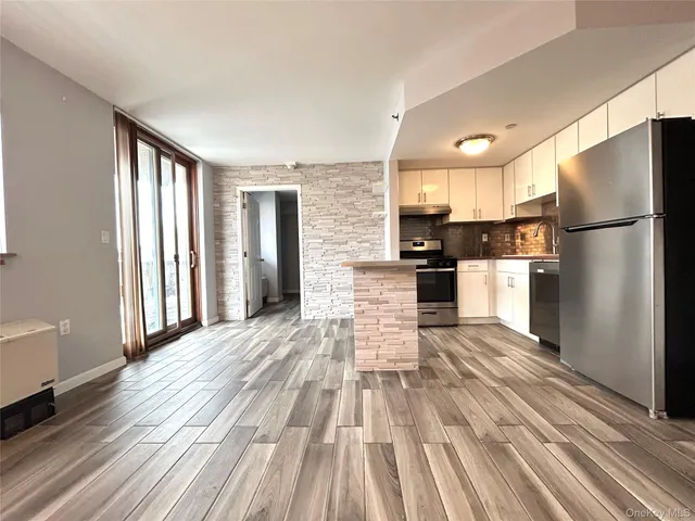 a view of kitchen with stainless steel appliances refrigerator stove microwave and cabinets