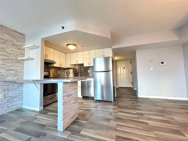 a kitchen with a refrigerator and a stove top oven