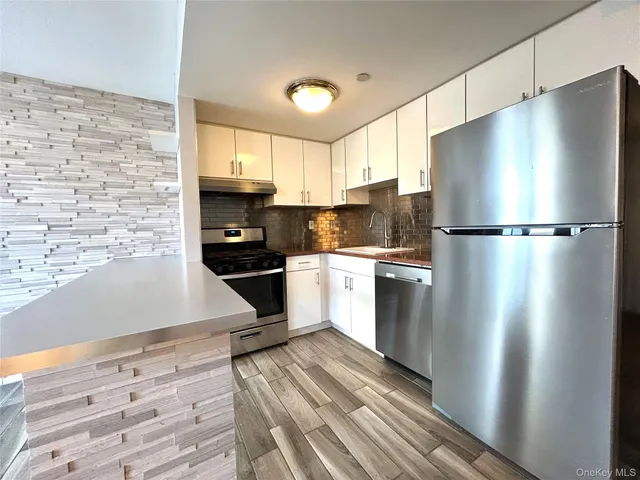a kitchen with stainless steel appliances a refrigerator sink and cabinets