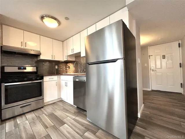 a kitchen with a refrigerator and a stove top oven