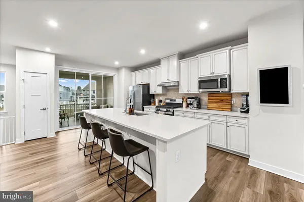 a kitchen with a table chairs refrigerator and microwave