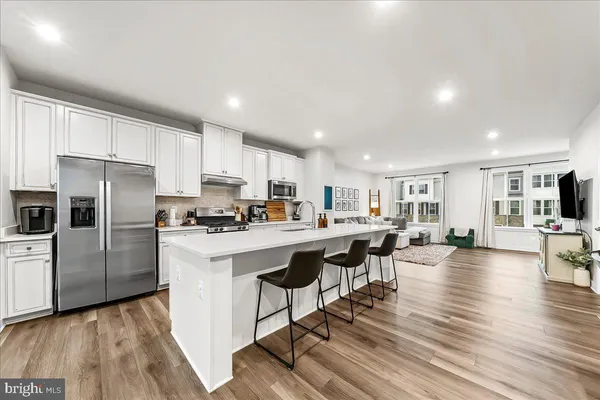 a kitchen with a sink a counter top space stainless steel appliances and cabinets