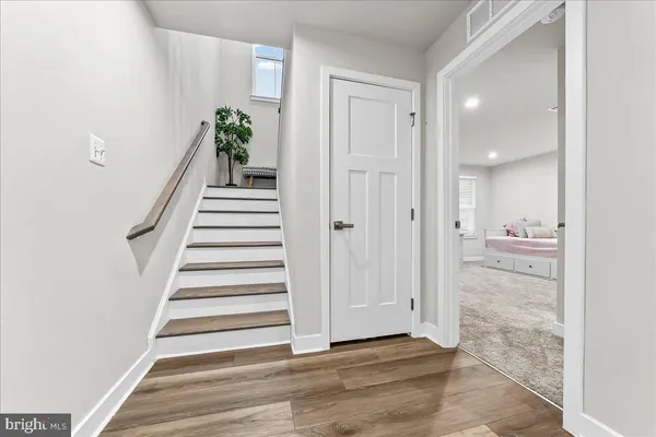a view of a hallway with wooden floor and staircase