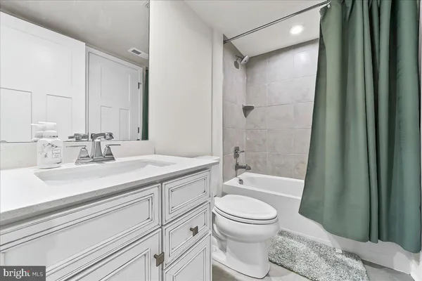a bathroom with a sink a toilet a mirror and shower