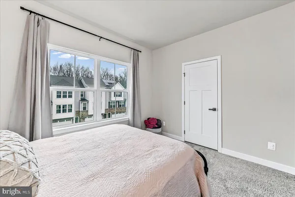 a bedroom with a bed and a large window