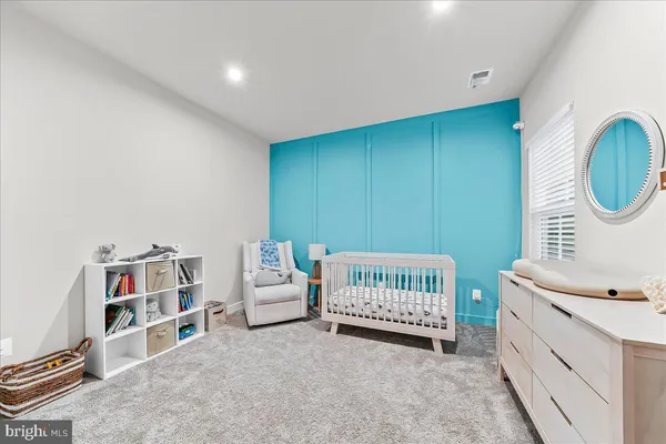 a room with a baby crib and a wooden floor