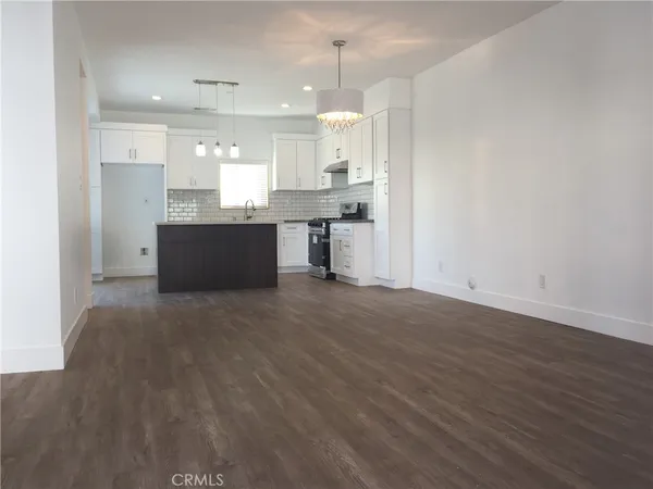a kitchen with granite countertop a sink cabinets and stainless steel appliances