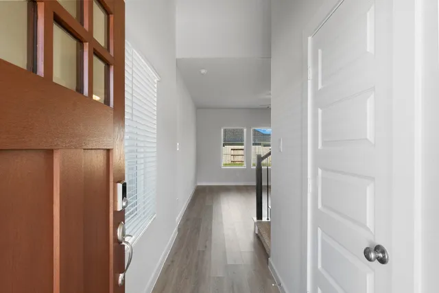 a view of a hallway with wooden floor and staircase