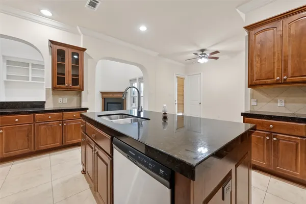 a open kitchen with kitchen island granite countertop a refrigerator and a sink