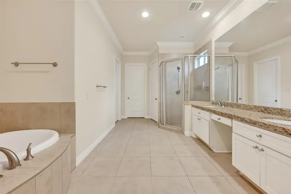 a bathroom with a granite countertop double vanity sink and mirror