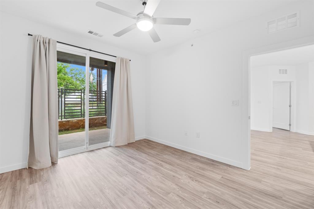 4801 Springdale Road, Unit 2010 Austin, TX 78723 - Photo 9 of 34 Bright room featuring light wood-finish flooring, white walls, and a ceiling fan with integrated lighting