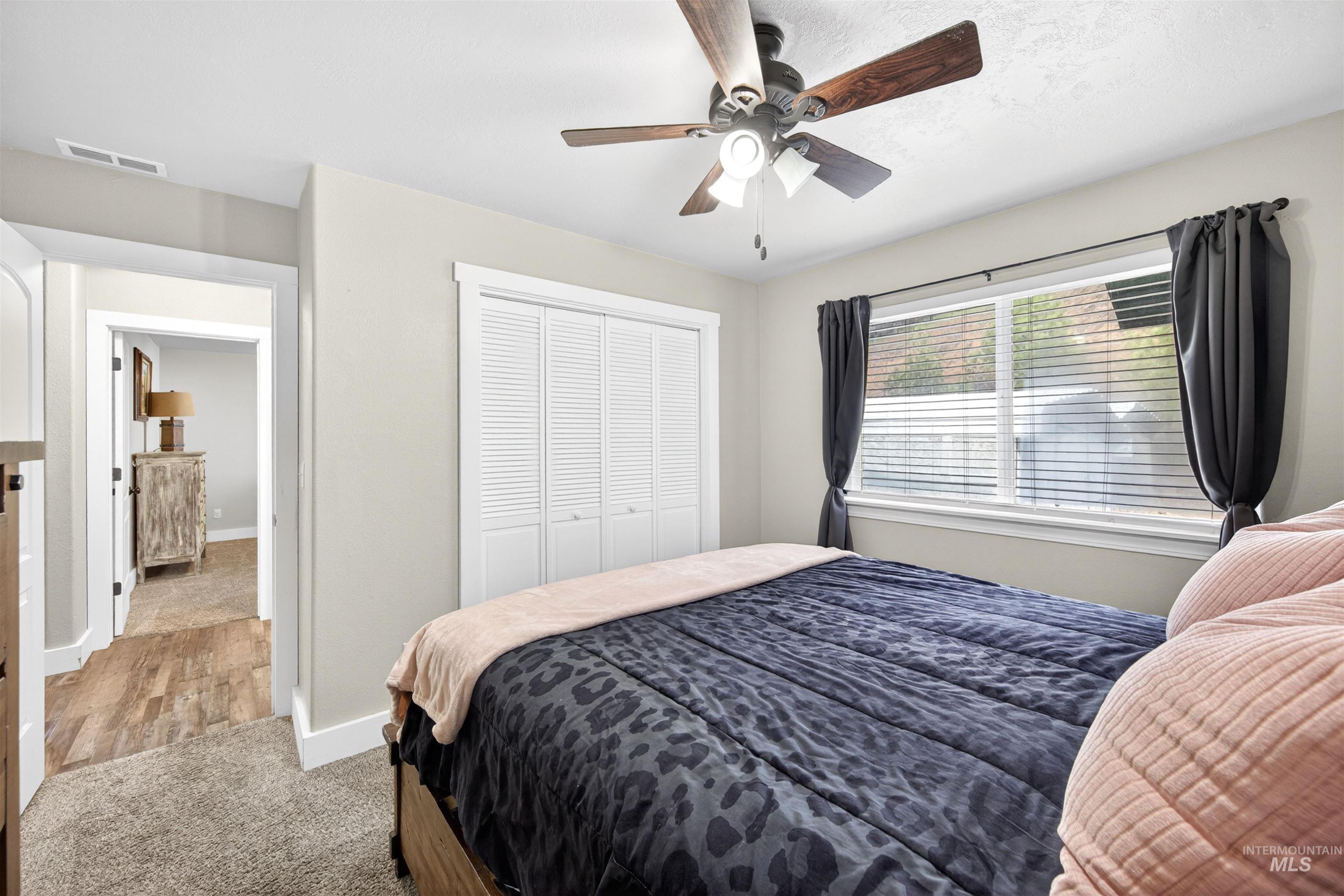 4 Round Up Circle Boise, ID 83716 - Photo 29 of 47 Bedroom featuring a ceiling fan, white louvered bifold closet doors, a window with horizontal blinds, and neutral wall paint