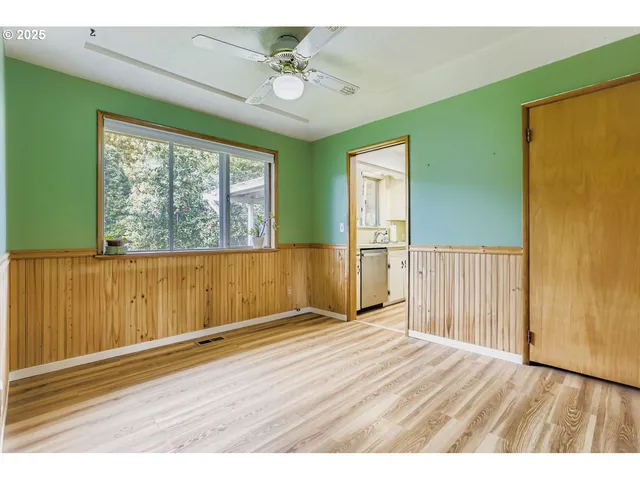 en empty room with wooden floor and windows