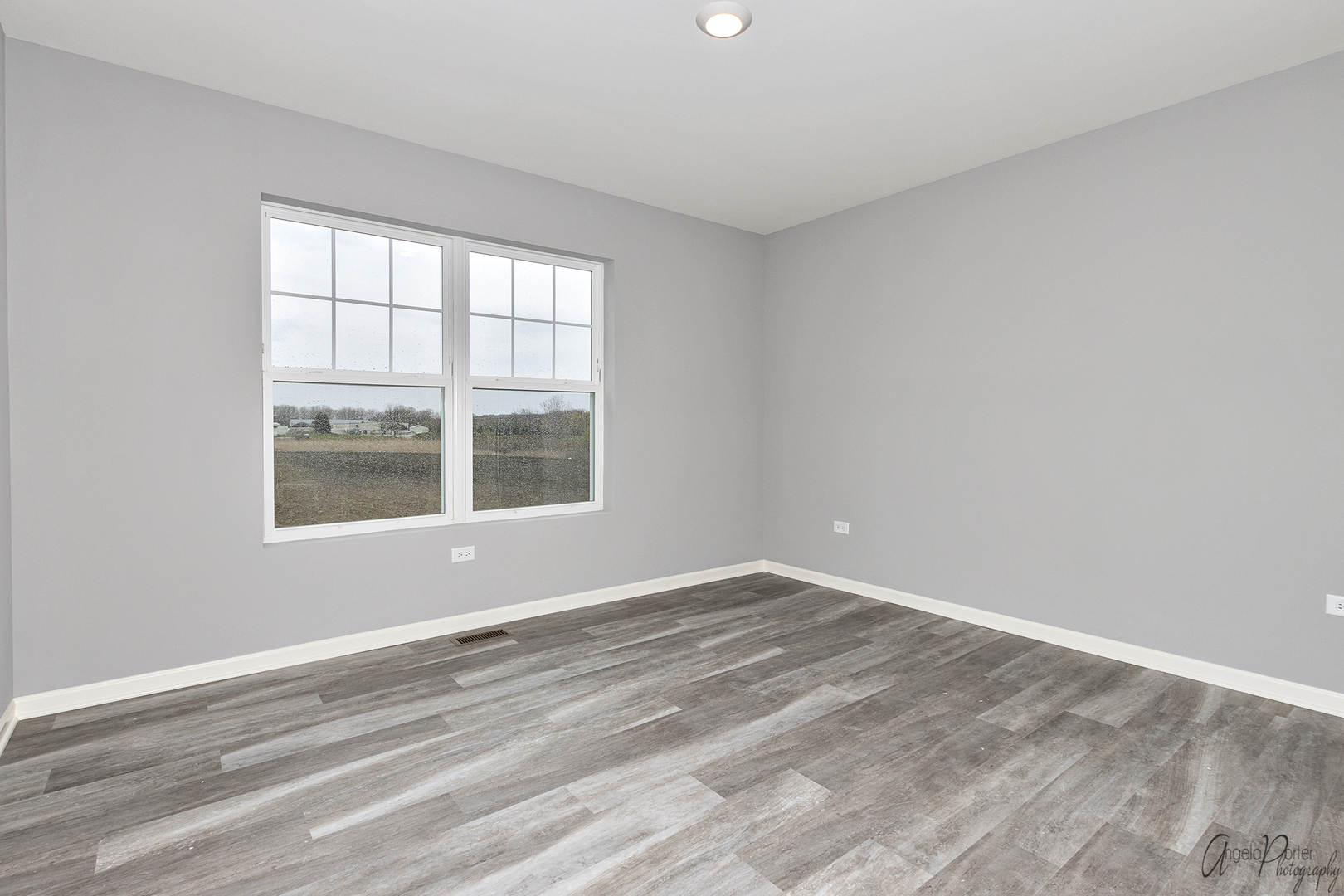 4012 Monica Lane, Unit 2 Johnsburg, IL 60051 - Photo 23 of 33 a view of an empty room with wooden floor and a window
