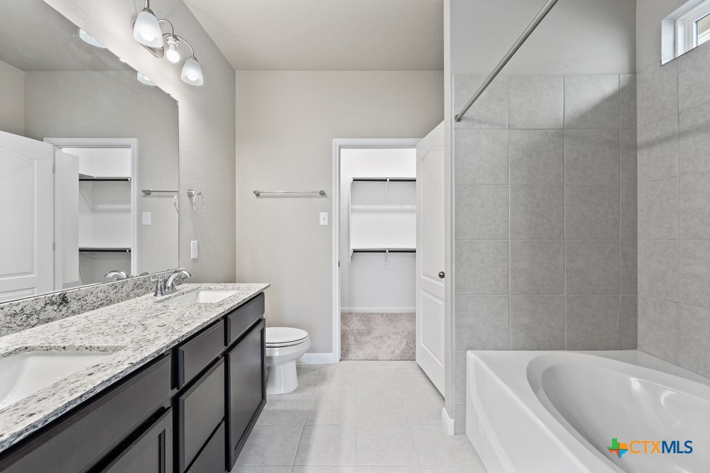 1028 Coriander Road Temple, TX 76501 - Photo 17 of 23 a bathroom with a granite countertop sink a toilet and bathtub